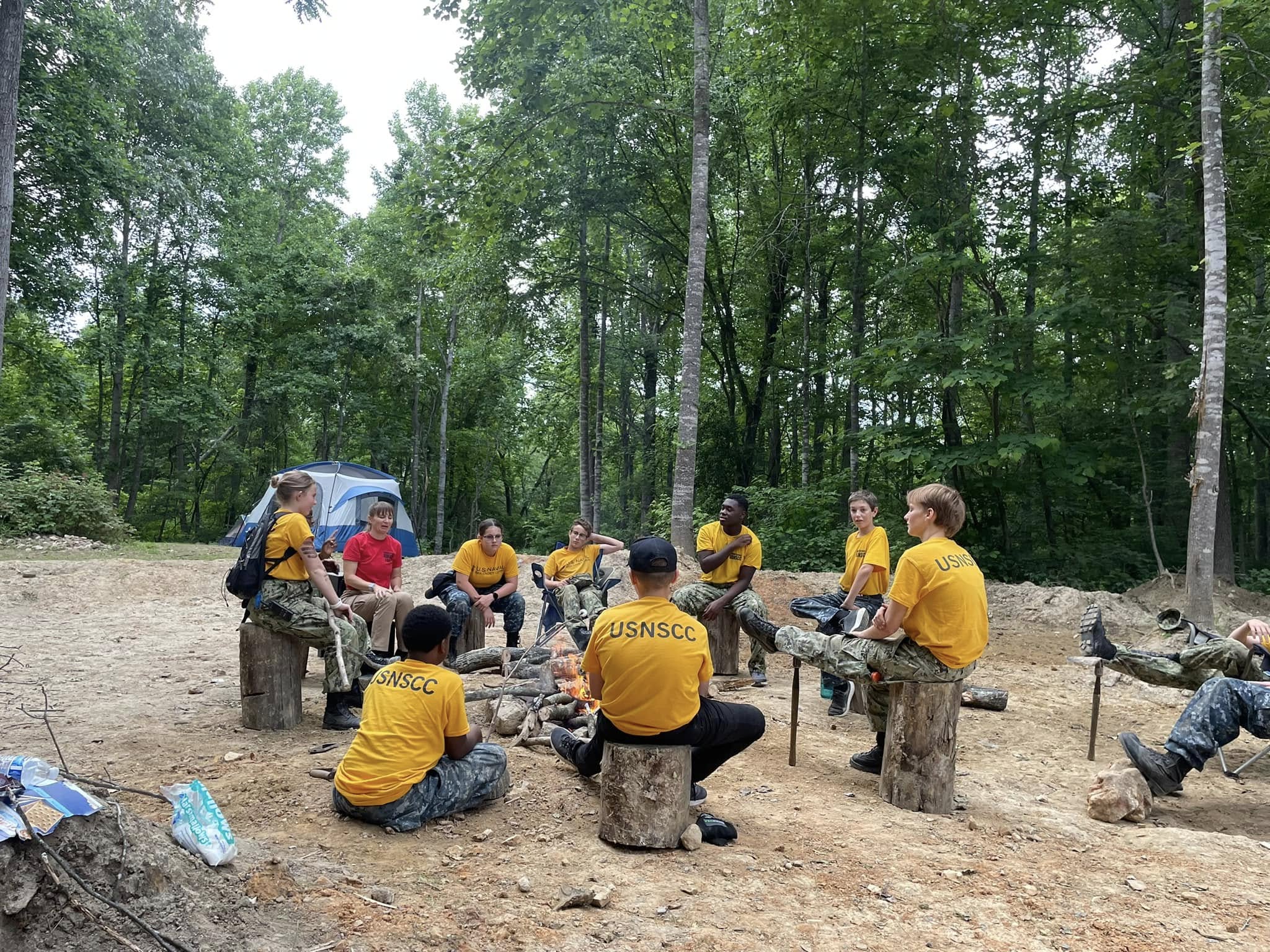 Cadets seated around a campfire during outdoor training