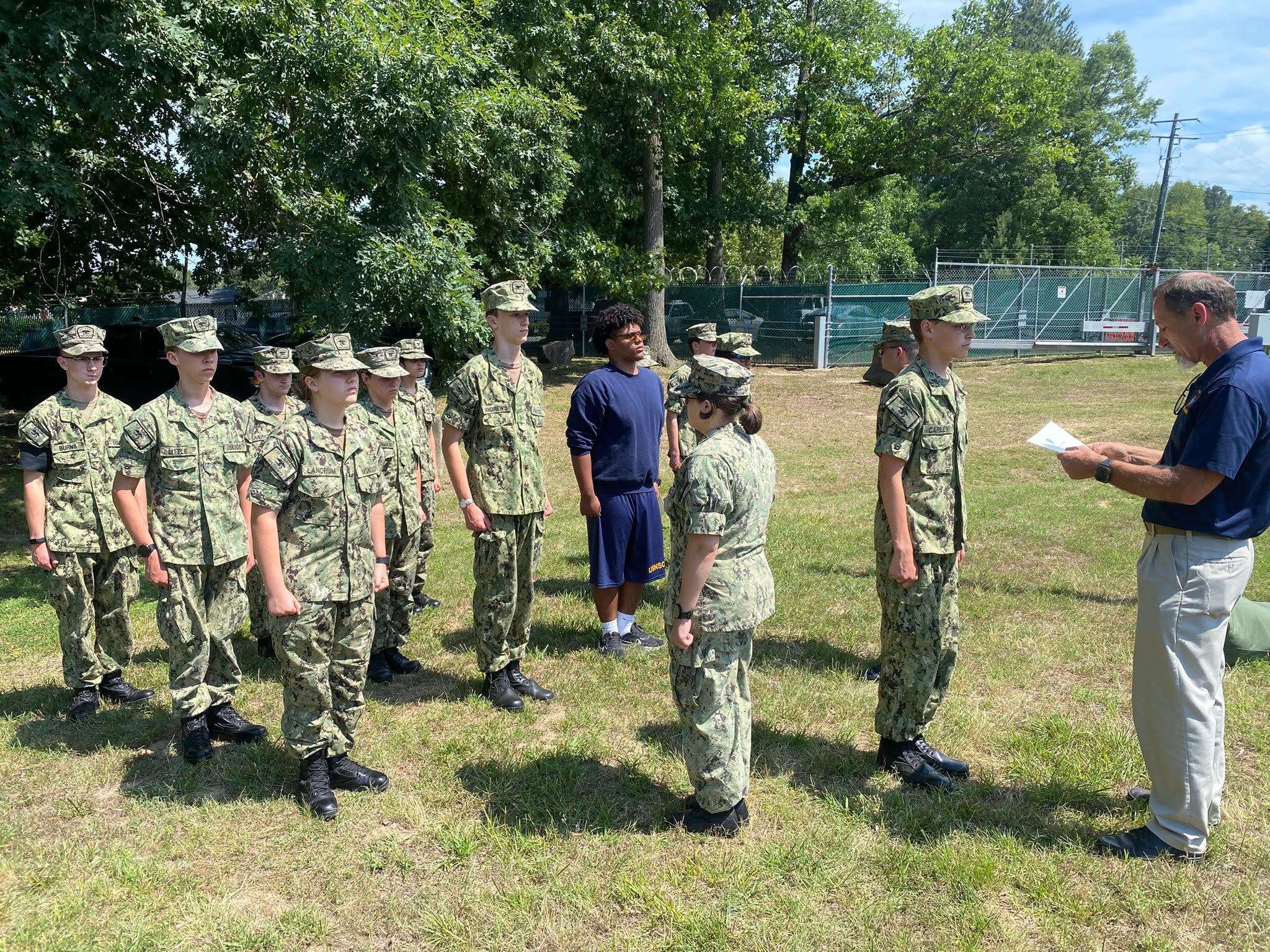 Cadets in formation being addressed by an adult officer