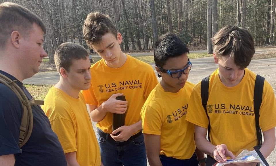 Four cadets huddled over a map during land navigation training