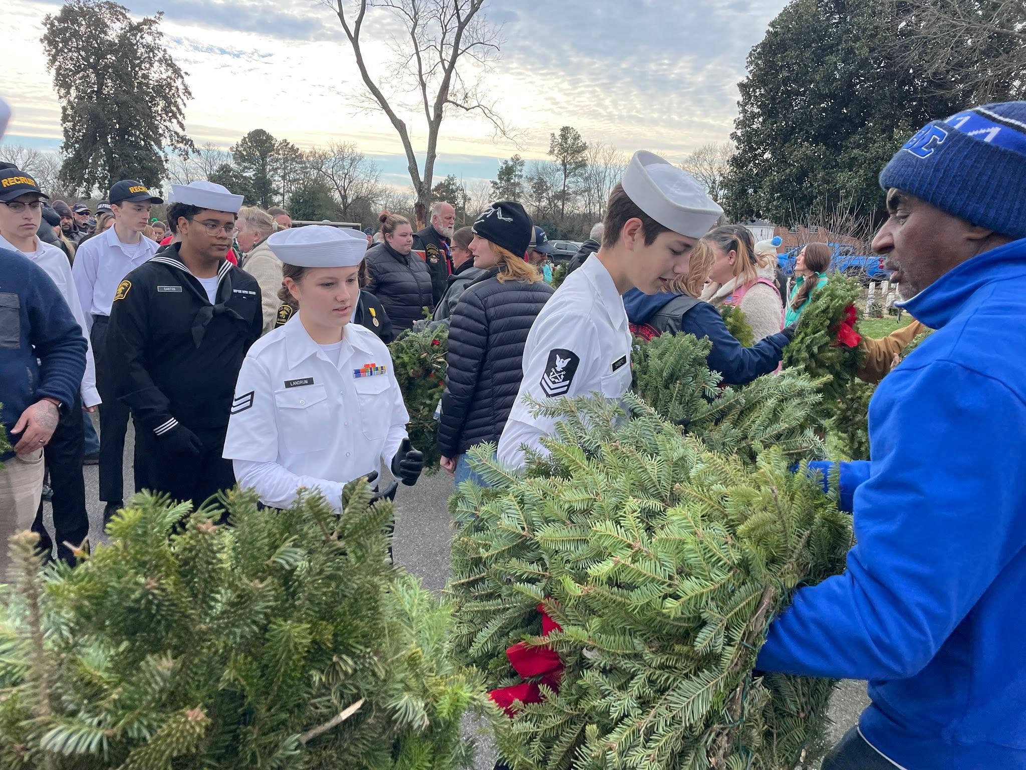 Cadets in white dress uniforms carrying wreaths during Wreaths Across America