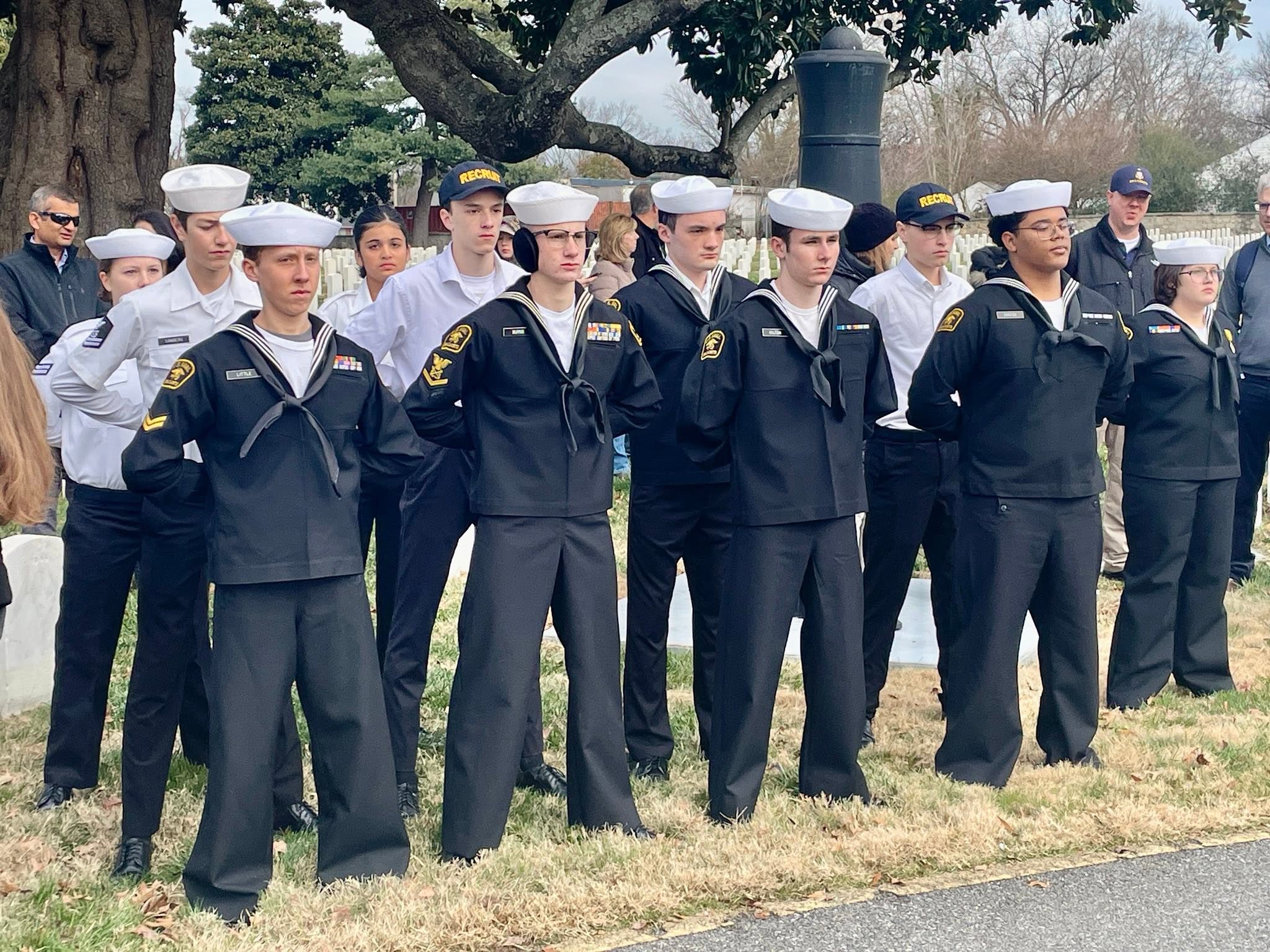 Group of cadets in dress blues and whites at a cemetery ceremony