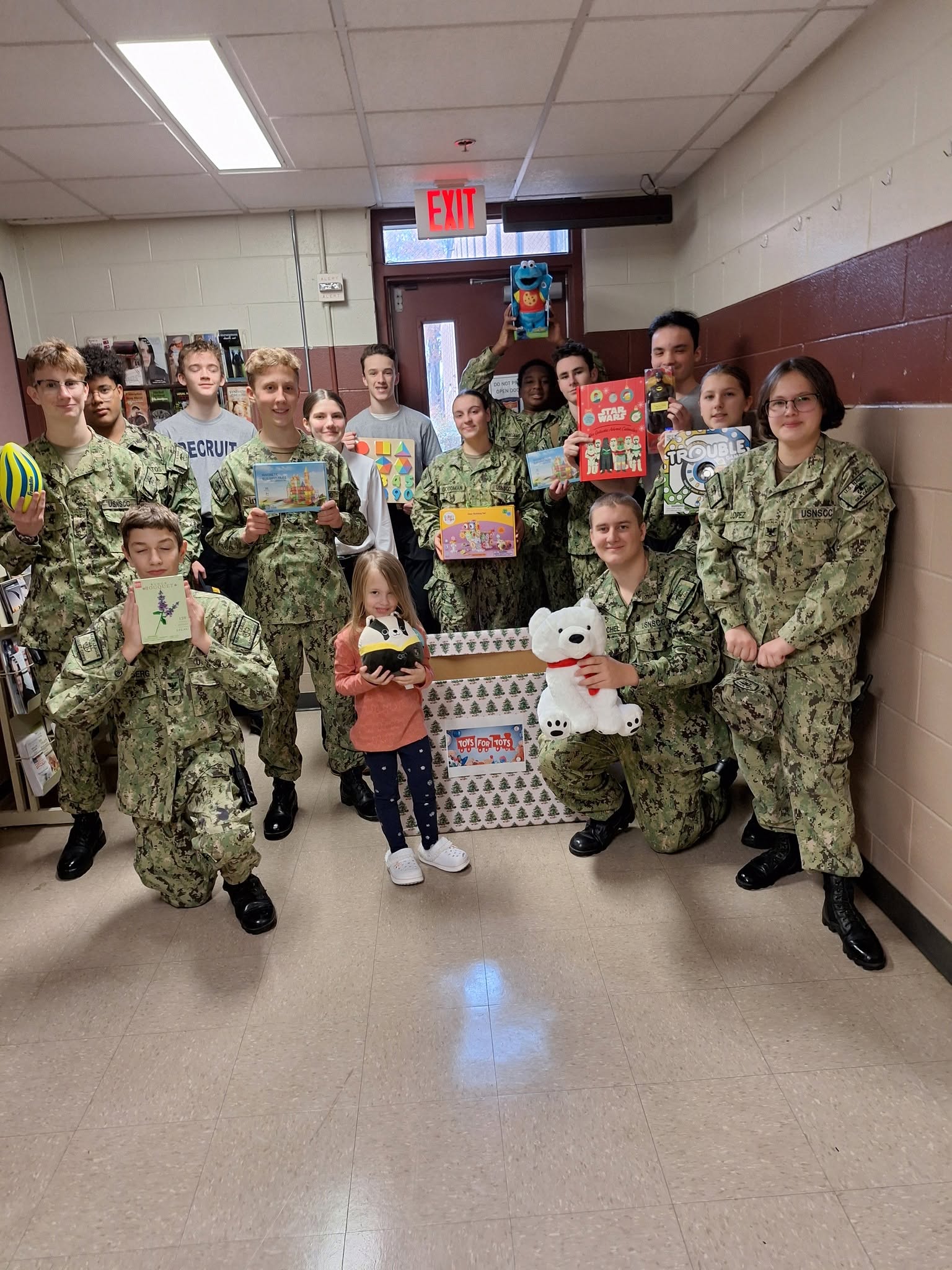 America Division cadets holding Toys for Tots donations with smiling community members