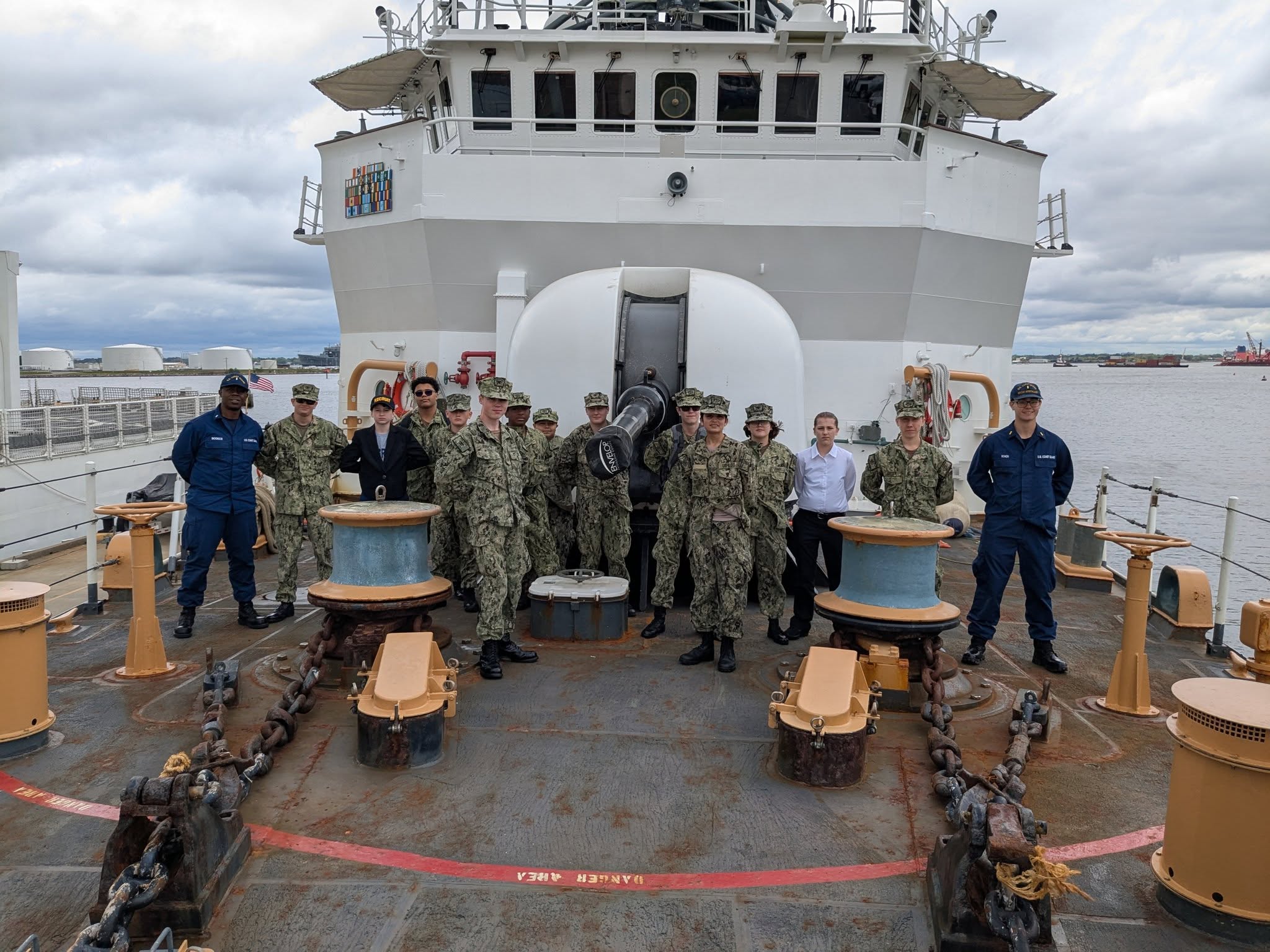 Cadets on the deck of a Coast Guard cutter in the harbor