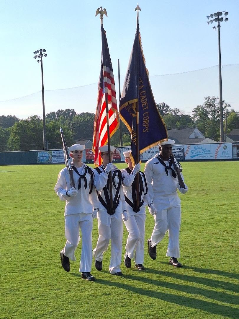 America Division color guard marching at golden hour carrying the Sea Cadet Corps flag
